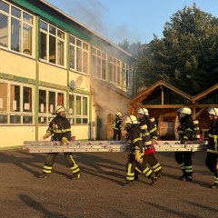 Feuerwehrangehörige bringen Leiter in Stellung