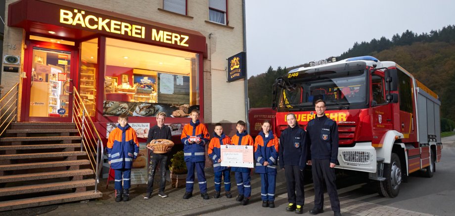 Michael Merz, Jugendliche der Jugendfeuerwehr und Jugendwarte vor Bäckerei Merz bei Spendenübergabe