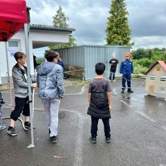 Kids löschen das Brandhaus mit Kübelspritze