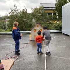 Löschen des Brandhauses mit Kübelspritze