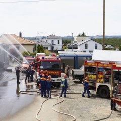 Brand Industriehalle wird gelöscht, mehrere Löschfahrzeuge am Einsatzort