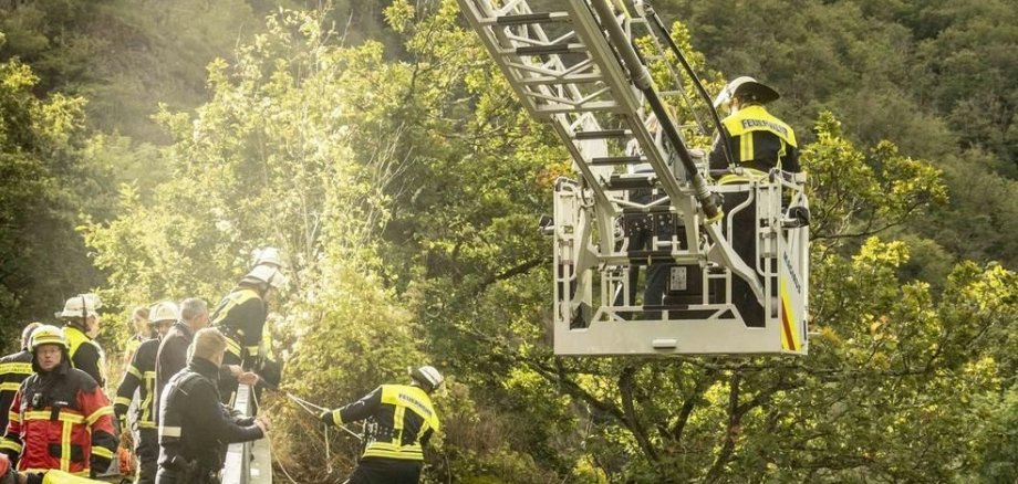 Drehleiter und Feuerwehrangehörige an einer Brücke