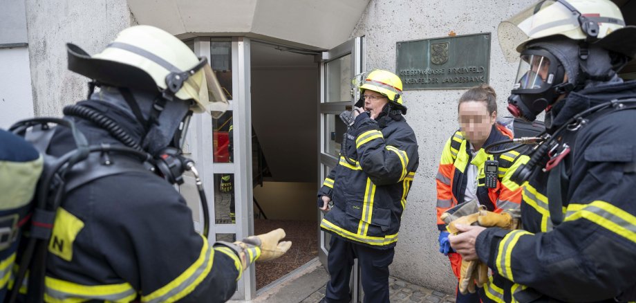 Feuerwehrangehörige vor Einsatzobjekt